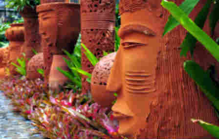 clay tiki heads used as a decorative garden accent