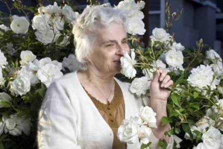 photo of an older woman smelling the roses